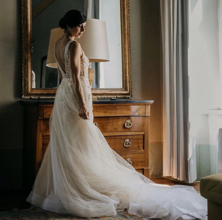 Una sposa elegante davanti allo specchio dorato durante la vestizione
